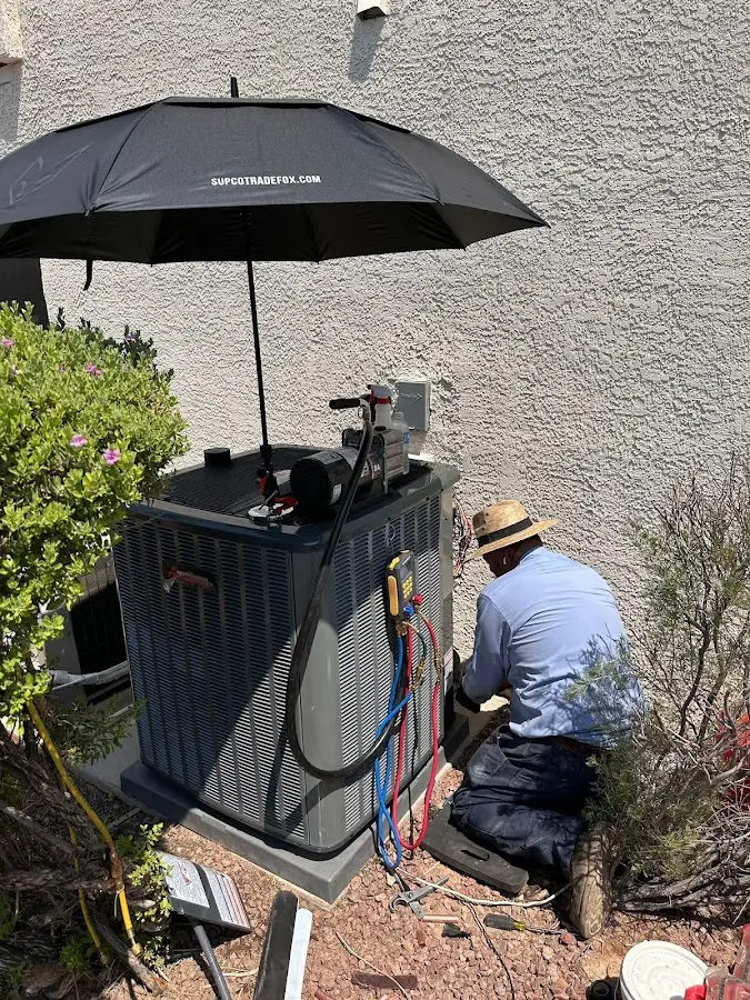 HVAC technician performing outdoor AC maintenance in Goffstown